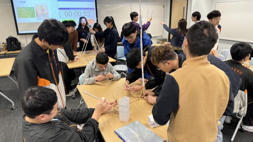 Students and volunteers building paper tower and Roman Catapult