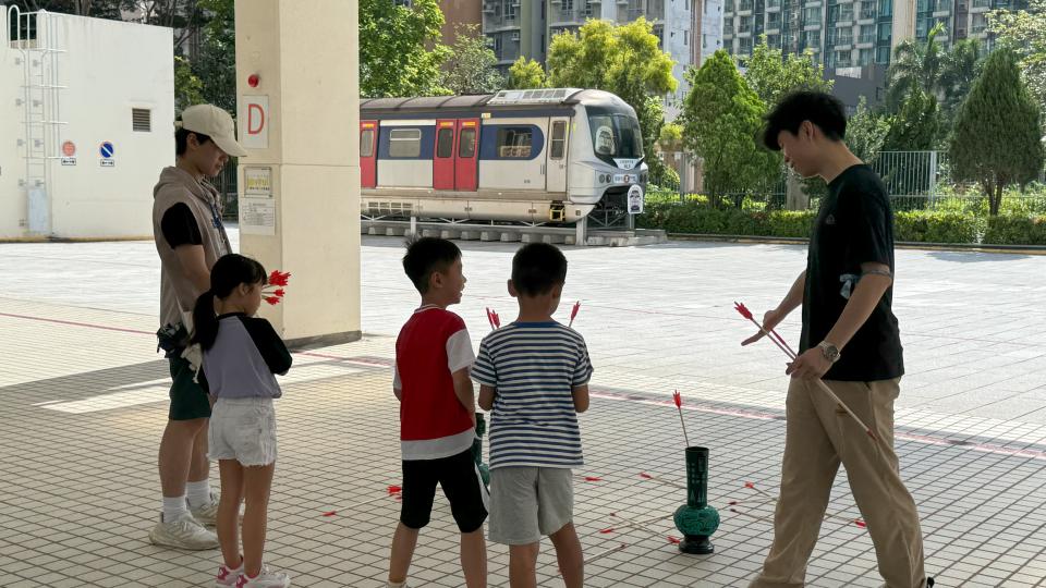 Volunteers guiding children in learning about Pitch-Pot
