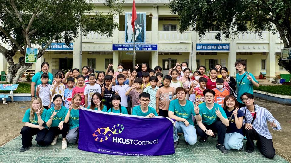 Volunteers and local children gathering for a group photo after completing the teaching