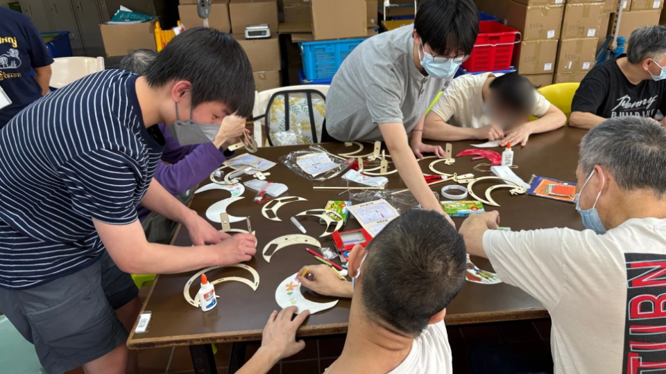 Volunteers and hostel residents crafting a Mid-Autumn lantern