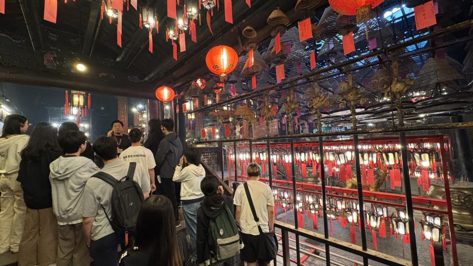 Guide giving a tour and explaining to students on rituals