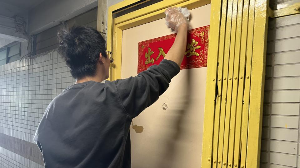 Volunteer cleaning the front gate for an elderly resident