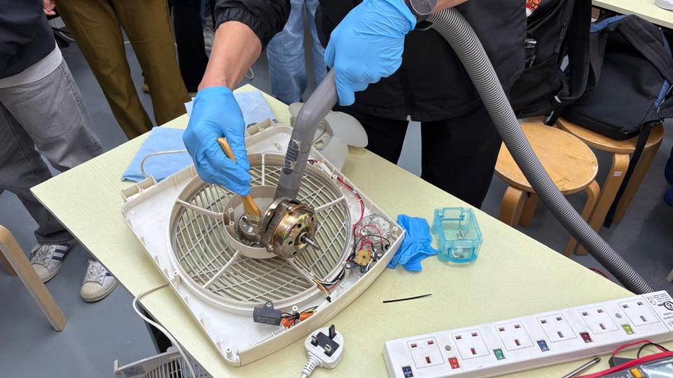 A participant repairing an old electric fan