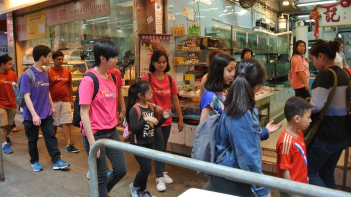 Volunteers and the ethnic minority teenagers walking along Wan Chai District to learn more about the local community