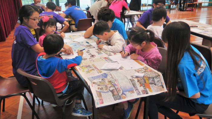 Volunteers leading the children to building paper houses together