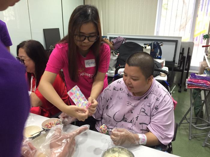 Volunteers and physically challenged adults making the "cake pop" together.