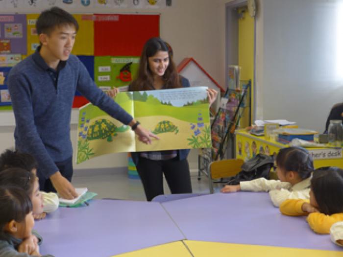 Volunteers serving as reading buddies for children