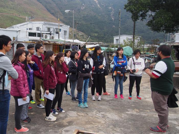 Mr Yuen, staff from YWCA, telling volunteers the history of Tai O