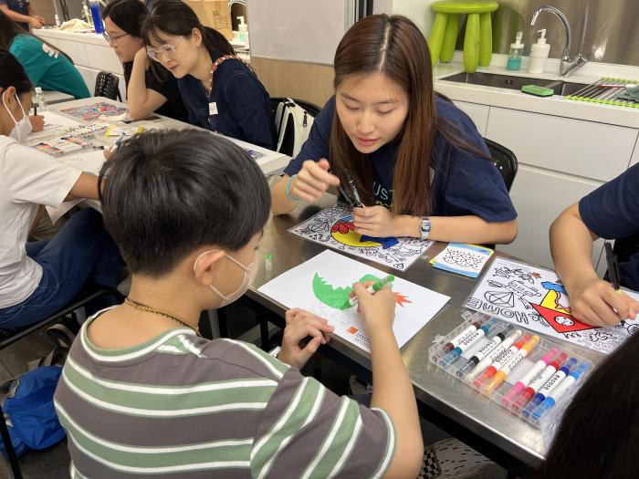 Volunteer coaching a child drawing