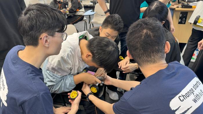 Volunteers teaching secondary school students building STEM car