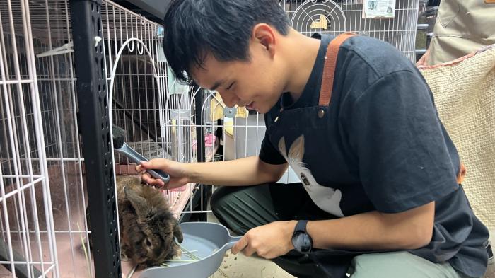 Student cleaning the cage