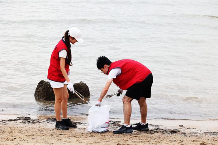 Volunteers picking up rubbish along the beach during 2024 Coastal Cleanup Action