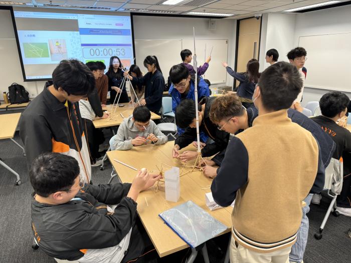 Students and volunteers building paper tower and Roman Catapult