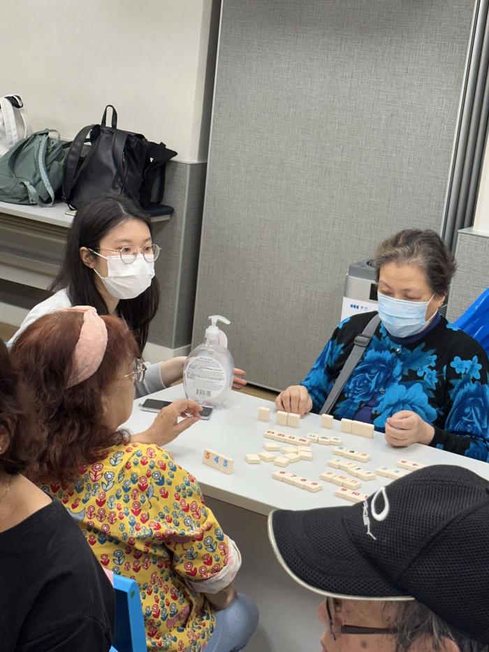 Students teaching elderly how to play Rummikub