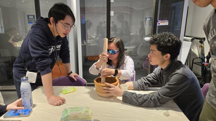 Volunteers assisting a VIP in hands-on experience of making Leicha