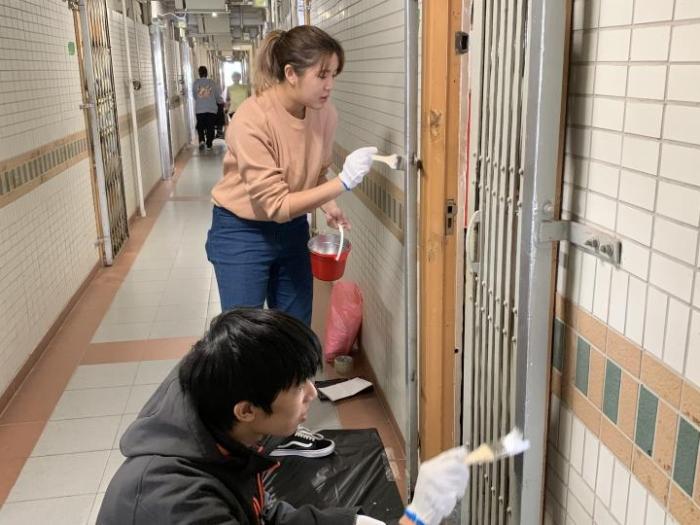 Volunteers cleaning gates and doors of elderly's homes