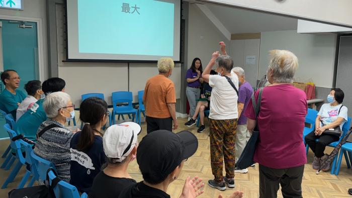 Volunteers teaching elderly to do exericise