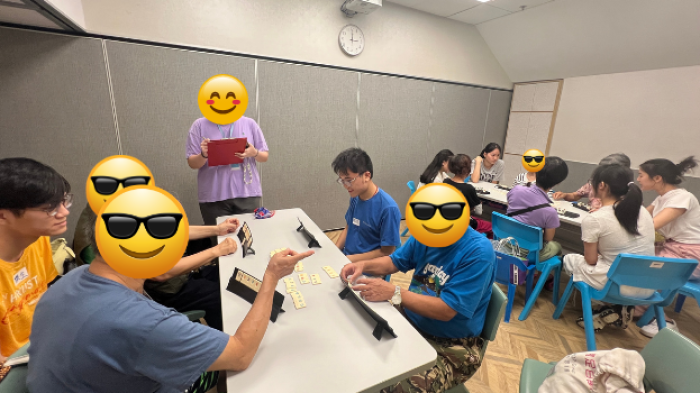 Students and elderly enjoying Rummikub together
