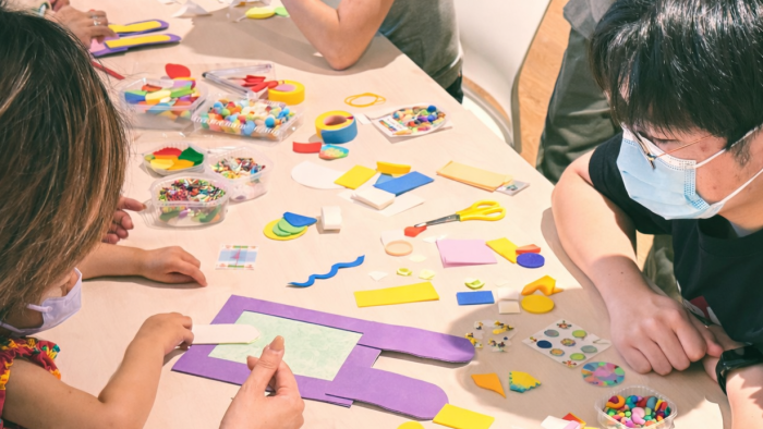 Volunteers and children co-creating photo frames