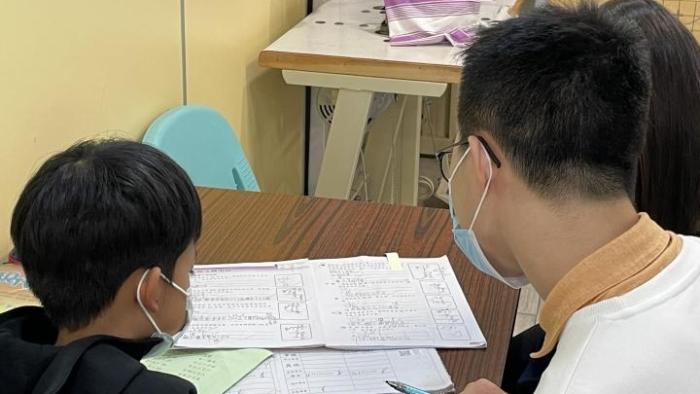 Volunteer teaching primary school student.